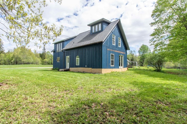 174 Andrews Rd, Holland, VT 05830 - view of side of home with board and batten siding, a lawn, and a shingled roof