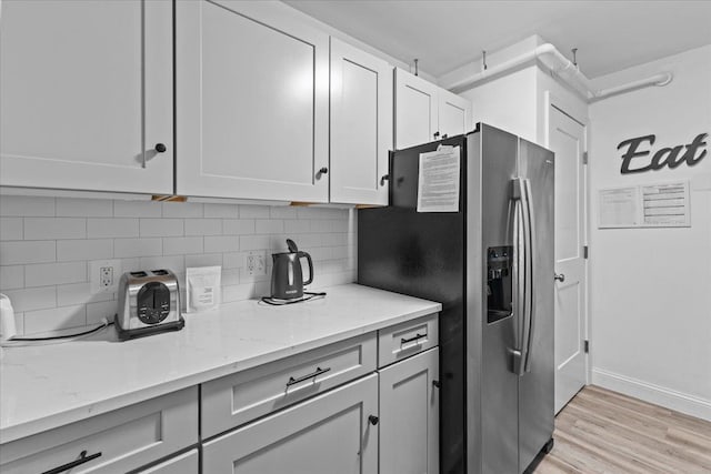109 Mountainside Dr Unit G202, Stowe, VT 05672 - kitchen with stainless steel refrigerator with ice dispenser, backsplash, light wood-style floors, and light stone countertops