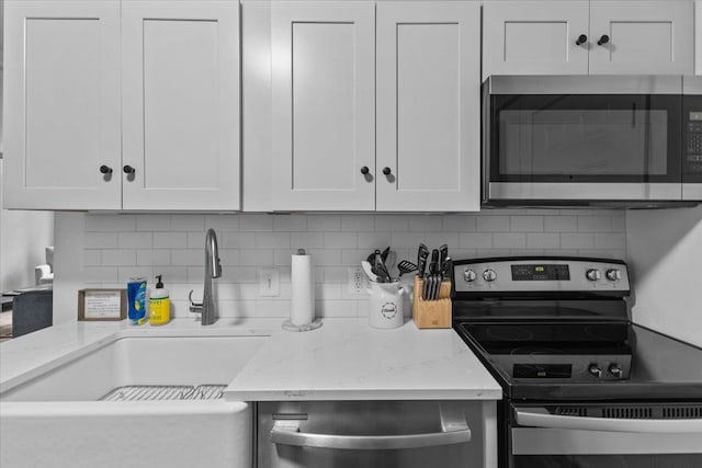 109 Mountainside Dr Unit G202, Stowe, VT 05672 - kitchen with stainless steel appliances, tasteful backsplash, a sink, and white cabinetry