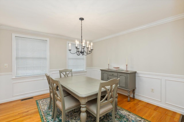 2 Cortland Rd, Milford, NH 03055 - dining area featuring a chandelier, light wood-type flooring, crown molding, a decorative wall, and wainscoting
