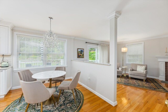 2 Cortland Rd, Milford, NH 03055 - dining room with ornamental molding, light wood-style flooring, a chandelier, baseboards, and a fireplace