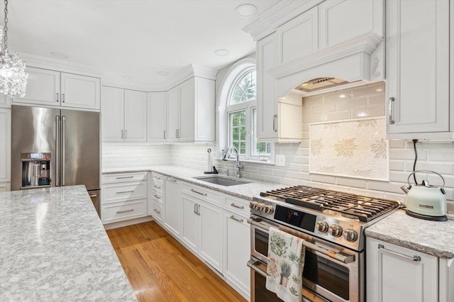 2 Cortland Rd, Milford, NH 03055 - kitchen with stainless steel appliances, a sink, white cabinetry, light wood-type flooring, and decorative backsplash