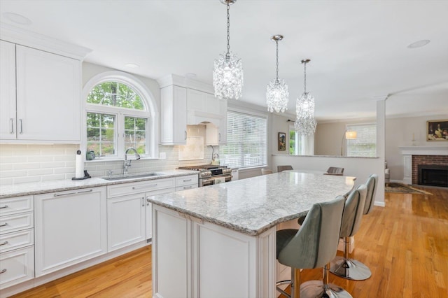 2 Cortland Rd, Milford, NH 03055 - kitchen featuring a sink, high end range, light wood-style flooring, a center island, and a chandelier