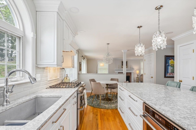 2 Cortland Rd, Milford, NH 03055 - kitchen featuring appliances with stainless steel finishes, a sink, a chandelier, light wood finished floors, and backsplash