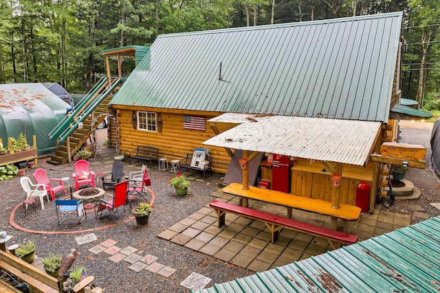 18 Mayflower Ln, Moultonborough, NH 03254 - back of house featuring metal roof, an outdoor fire pit, log siding, and a patio area