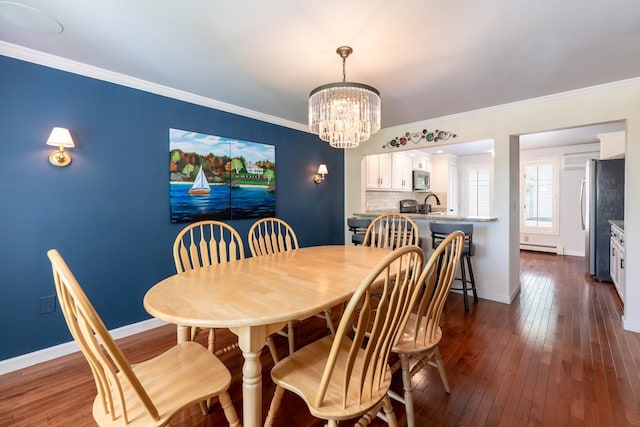 21 Hawk Ridge Rd, Meredith, NH 03253 - dining space featuring a chandelier, a baseboard heating unit, baseboards, ornamental molding, and dark wood-style floors