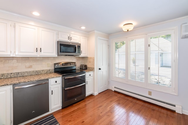 21 Hawk Ridge Rd, Meredith, NH 03253 - kitchen featuring appliances with stainless steel finishes, a baseboard radiator, white cabinetry, decorative backsplash, and crown molding