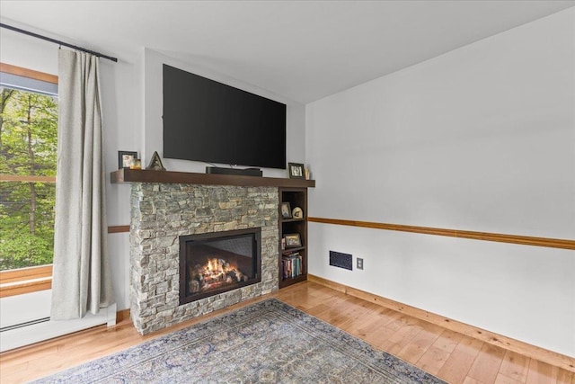 100 Maplewood Ave, Milton, VT 05468 - unfurnished living room with a fireplace, hardwood / wood-style floors, and baseboards
