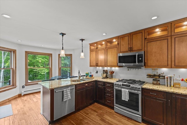 100 Maplewood Ave, Milton, VT 05468 - kitchen with appliances with stainless steel finishes, a sink, a baseboard heating unit, a peninsula, and wood finished floors