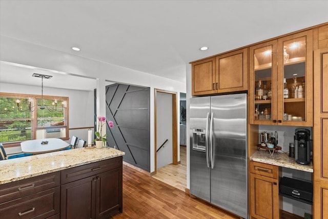 100 Maplewood Ave, Milton, VT 05468 - kitchen featuring stainless steel fridge, light wood finished floors, brown cabinetry, glass insert cabinets, and recessed lighting
