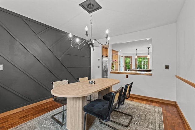 100 Maplewood Ave, Milton, VT 05468 - dining room featuring a chandelier, baseboards, and hardwood / wood-style floors