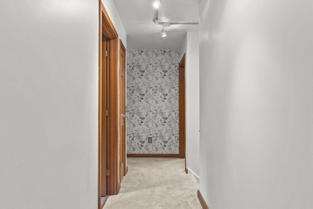100 Maplewood Ave, Milton, VT 05468 - hallway featuring light carpet, baseboards, wallpapered walls, and rail lighting