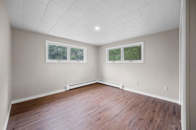 1572 Stowe Hollow Rd, Stowe, VT 05672 - spare room featuring wood finished floors, baseboards, a baseboard radiator, and wood walls