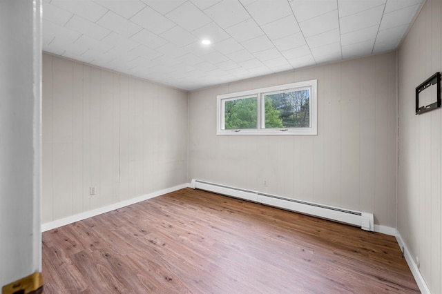 1572 Stowe Hollow Rd, Stowe, VT 05672 - spare room featuring baseboard heating, wood finished floors, and wooden walls