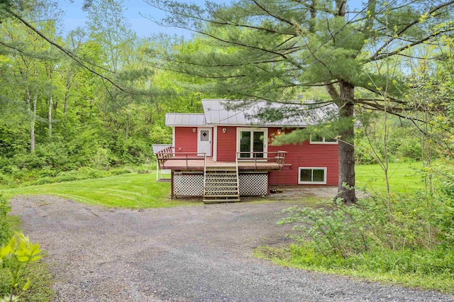 1572 Stowe Hollow Rd, Stowe, VT 05672 - view of front facade featuring a wooden deck, a front lawn, a wooded view, and metal roof