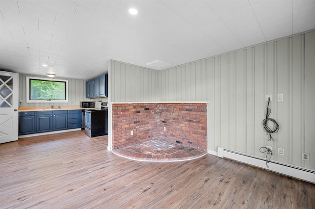 1572 Stowe Hollow Rd, Stowe, VT 05672 - unfurnished living room featuring a sink, light wood finished floors, and baseboard heating