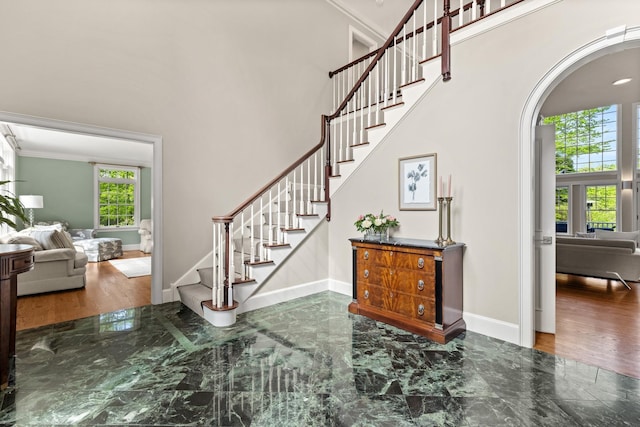 34 Orchard Hill Rd, Greenland, NH 03840 - foyer featuring arched walkways, stairs, ornamental molding, a towering ceiling, and baseboards