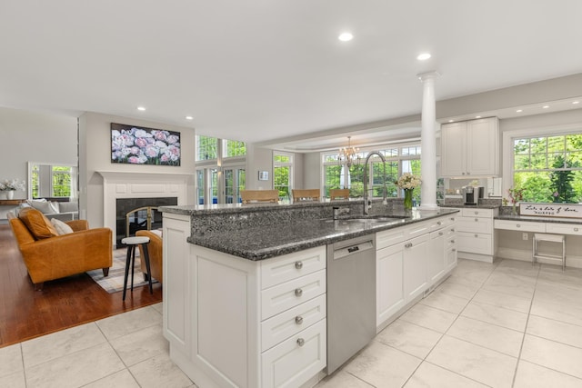 34 Orchard Hill Rd, Greenland, NH 03840 - kitchen with stainless steel dishwasher, a sink, a glass covered fireplace, plenty of natural light, and recessed lighting