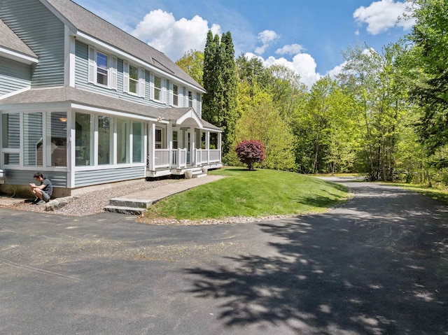 12 Drew Ln, Laconia, NH 03246 - view of side of property featuring roof with shingles, covered porch, and a yard