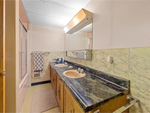 37 Dickinson Dr, Northfield, VT 05664 - full bath featuring tile walls, wainscoting, double vanity, and enclosed tub / shower combo