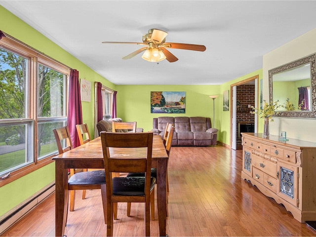 37 Dickinson Dr, Northfield, VT 05664 - dining area with baseboard heating, a ceiling fan, wood finished floors, and a fireplace