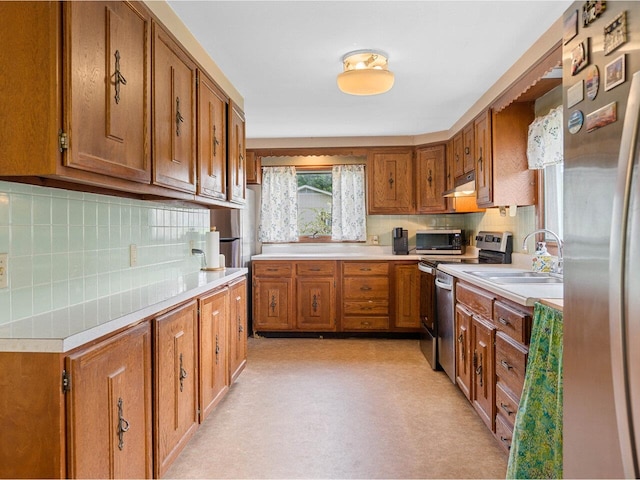 37 Dickinson Dr, Northfield, VT 05664 - kitchen featuring under cabinet range hood, stainless steel appliances, a sink, brown cabinets, and light countertops