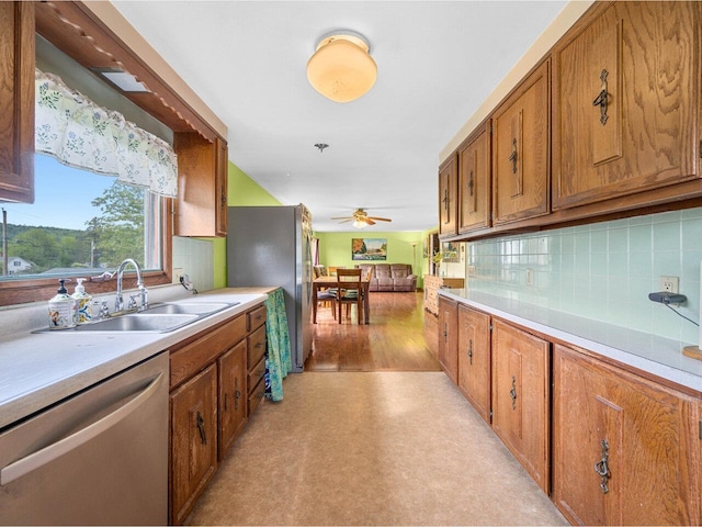 37 Dickinson Dr, Northfield, VT 05664 - kitchen with appliances with stainless steel finishes, a sink, brown cabinetry, light countertops, and tasteful backsplash