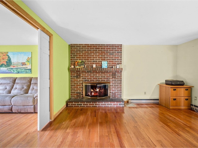 37 Dickinson Dr, Northfield, VT 05664 - unfurnished living room featuring baseboard heating, wood finished floors, and a fireplace