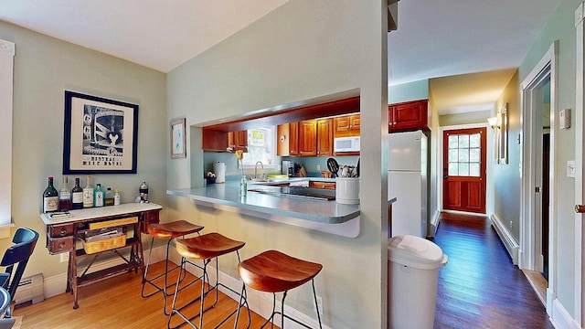 825 S End Rd, North Hero, VT 05457 - kitchen with white appliances, wood finished floors, a kitchen bar, and healthy amount of natural light