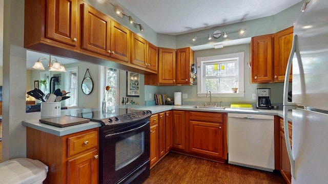 825 S End Rd, North Hero, VT 05457 - kitchen featuring white appliances, a sink, brown cabinetry, a peninsula, and dark wood-style flooring