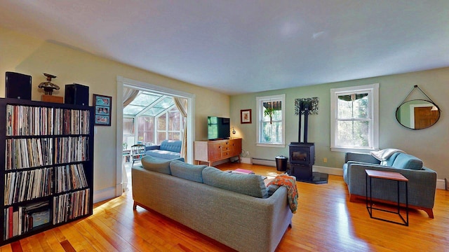 825 S End Rd, North Hero, VT 05457 - living room featuring a wood stove, light wood finished floors, baseboard heating, and baseboards