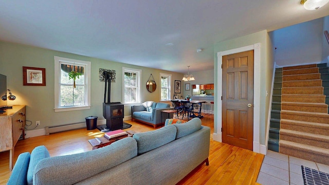 825 S End Rd, North Hero, VT 05457 - living area with baseboard heating, stairs, a wood stove, and light wood finished floors