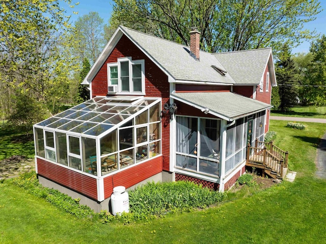 825 S End Rd, North Hero, VT 05457 - rear view of house with a sunroom, a chimney, a shingled roof, a yard, and cooling unit