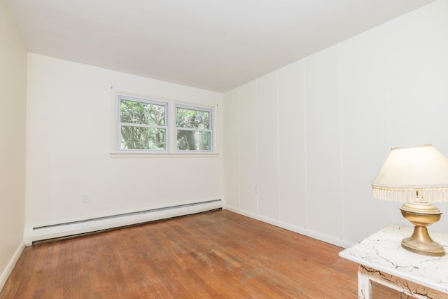 18 Riverdale Ave, Dover, NH 03820 - spare room featuring a baseboard heating unit, wood-type flooring, and baseboards