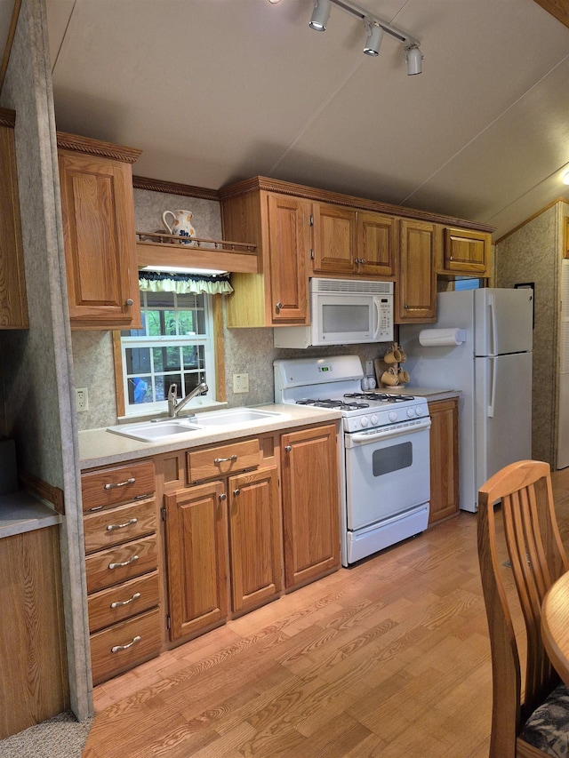 113 Oak Ln Unit 113, Wakefield, NH 03830 - kitchen featuring white appliances, a sink, light wood-style floors, light countertops, and brown cabinetry