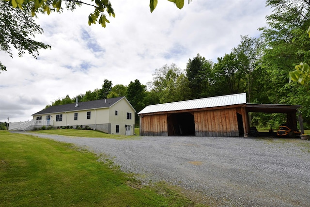 3900 Jersey St, Panton, VT 05491 - view of front of home with driveway, a carport, a front lawn, and an outbuilding