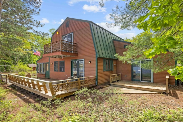 34 Winter Hill Ln, Andover, NH 03216 - back of property with a balcony, a gambrel roof, metal roof, a deck, and a standing seam roof