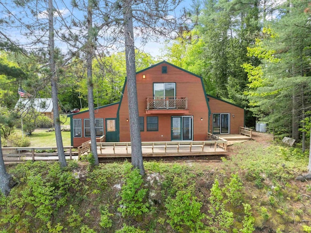 34 Winter Hill Ln, Andover, NH 03216 - rear view of house featuring a balcony, a gambrel roof, and a wooden deck