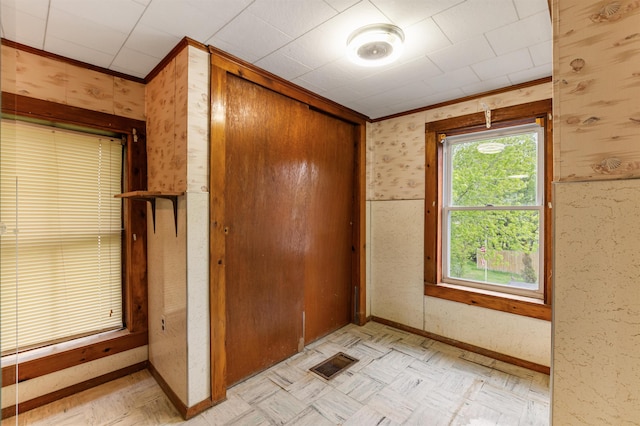 25 Eames St, Northumberland, NH 03582 - unfurnished bedroom with a closet, light flooring, wallpapered walls, crown molding, and baseboards