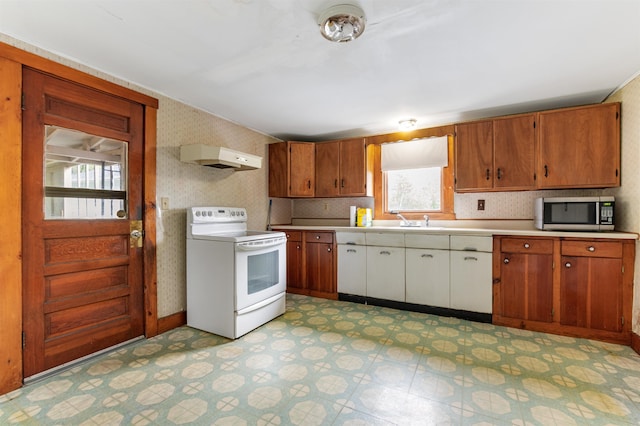 25 Eames St, Northumberland, NH 03582 - kitchen with white range with electric stovetop, stainless steel microwave, wallpapered walls, light flooring, and light countertops