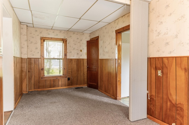 25 Eames St, Northumberland, NH 03582 - empty room featuring wainscoting, a paneled ceiling, wallpapered walls, wood walls, and carpet floors