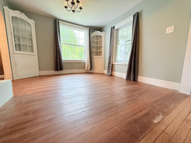 19 Gambier St, Claremont, NH 03743 - unfurnished dining area with a chandelier, plenty of natural light, and hardwood / wood-style floors