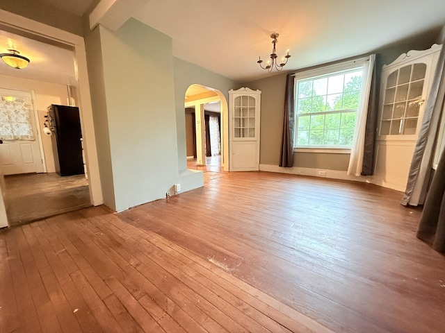 19 Gambier St, Claremont, NH 03743 - unfurnished dining area with arched walkways, a chandelier, and wood-type flooring
