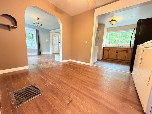 19 Gambier St, Claremont, NH 03743 - unfurnished dining area featuring arched walkways, light wood-type flooring, a chandelier, baseboards, and a sink