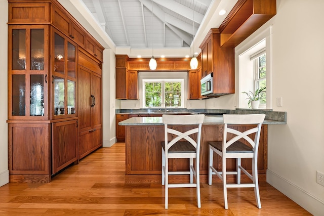 8 Wisteria Ln, Eliot, ME 03903 - kitchen featuring stainless steel microwave, light wood-style floors, brown cabinets, and wooden ceiling
