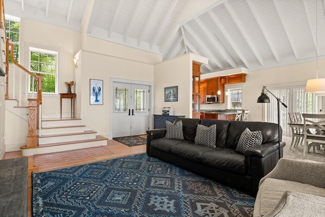 8 Wisteria Ln, Eliot, ME 03903 - living area featuring stairway, wood finished floors, plenty of natural light, beam ceiling, and high vaulted ceiling