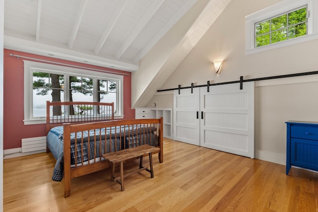 8 Wisteria Ln, Eliot, ME 03903 - bedroom with a barn door, light wood-style floors, and baseboards