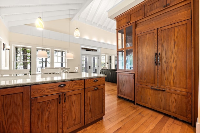 8 Wisteria Ln, Eliot, ME 03903 - kitchen featuring brown cabinets, light wood-style floors, hanging light fixtures, french doors, and light stone countertops