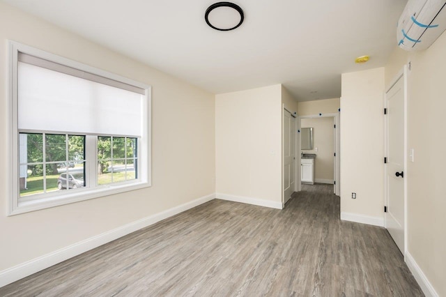 725 Central Ave Unit 101, Dover, NH 03820 - spare room featuring wood finished floors, a wall mounted air conditioner, and a smoke detector