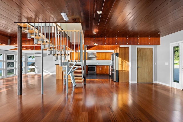 430 Clearwater Rd, Shelburne, VT 05482 - kitchen featuring stainless steel appliances, brown cabinetry, wood ceiling, dark wood-style floors, and wall chimney exhaust hood
